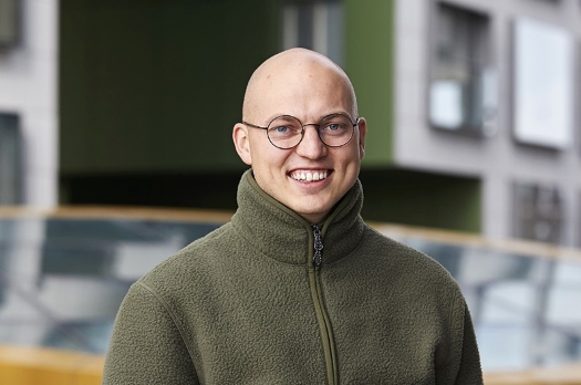 Lääkäri Lari Karjula poseeraa kadulla vihreässä fleece-takissa. 